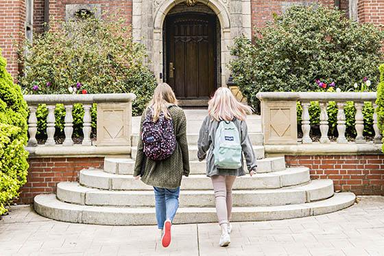 Two students walk into a historic mansion on Shadyside Campus